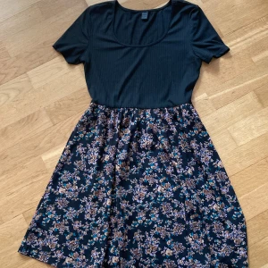 Svart blommig kortklänning - Svart & blommig kortklänning från Shein, perfekt till sommaren☀️Storlek M. Använd flera gånger men fortfarande i fint skick!