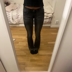 Svarta/mörk gråa lågmidjade bootcut jeans - Superfina och trendiga svarta/mörkgråa lågmidjade utsvängda jeans med fina detaljer. Hålen och ”slitnaderna ” är meningen att det ska vara så. Köpta i Brasilien för 550kr och knappt använda. Pris kan diskuteras vid snabb affär. Finns fler lågmidjade jeans, trendiga tröjor och väskor billigt i min profil! (Jag har köpt dessa på plick, detta är beskrivningen av den andra tjejen jag köpte av!!!!)