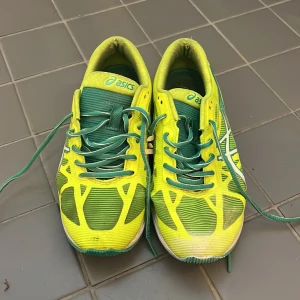 Gula och gröna löparskor från Asics - Snygga löparskor från Asics i en cool gul och grön färgkombination med vita detaljer. Skorna har snörning och en sportig design med ventilerande syntetmaterial.