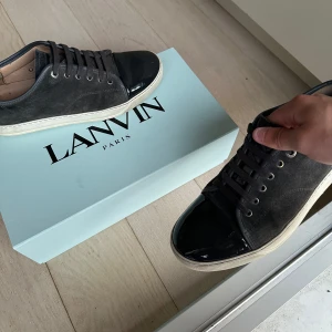 Lanvin i mörkgrå färg - Mörk gråa lanvins i storlek uk8 som motsvarar 42/43 i storlek, innermått i sulan är 28cm. Skon är i gott skick har används i ett sparsamt skick. Inga skador eller crease på toe utan den är mycket fin och glansig som man kan se på bilderna. Skick 7/10 over all. Box och extrasnören medföljer samt kvitto finns till skorna. För mer frågor är det bara att skriva 