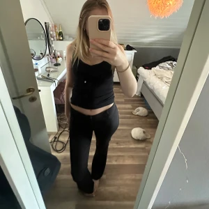 Svarta kostymbyxor - Säljer ett par svarta  kostymbyxor med raka ben och snygg passform. Byxorna har fickor bak med knappdetalj och stängs med dragkedja och knapp framtill. 