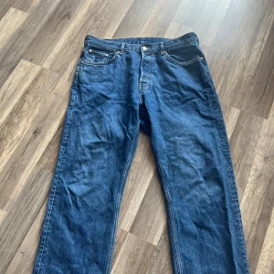 Blå Weekday Space jeans straight fit - Säljer ett par blå jeans från Weekday, modellen Space. De har rak passform, klassisk femficksdesign och normal midja. Jeansen är i 100% bomull och har snygga kontrastsömmar. Perfekta för en avslappnad och stilren look.