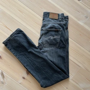 GråSvarta jeans från Nudie Jeans - Säljer ett par gråsvarta jeans från Nudie Jeans med klassisk femficksdesign. Jeansen har raka ben och normal passform, tillverkade i mjukt denimtyg. Modellen är "low slim jim” nypris 1800. Hör härna av er för fler bilder eller funderingar.