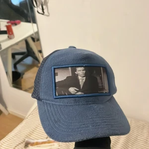 Velvet keps - Tja säljer en fet keps nu inför sommaren, nästan aldrig andvänd, på är trycket är Patrik bateman. Priset är ej hugget i sten! Hör av vid frågor