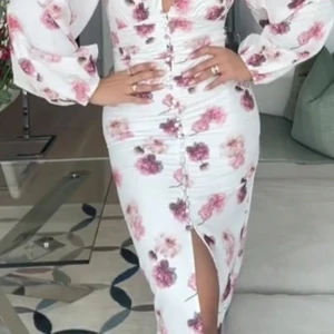 Vit blommig långklänning med slits - Lånade bilder. Ballon sleeve dress från ginatricor. Storlek 36. Säljes för 749kr eller bytes mot en storlek 38/40. Prislapp kvar. 