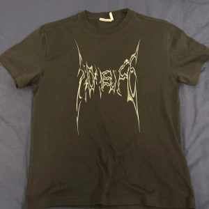 Svart t-shirt från Weekday - Snygg svart t-shirt från Weekday med ett coolt tryck i vitt på framsidan. Perfekt för en avslappnad stil. Tillverkad i mjukt material för extra komfort.