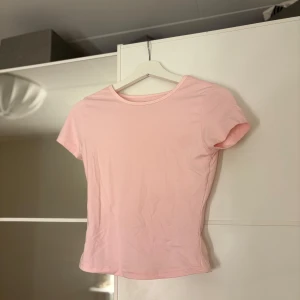 Rosa kortärmad t-shirt - Säljer en söt rosa t-shirt med korta ärmar. Den sitter tight och liknar den från Gina.