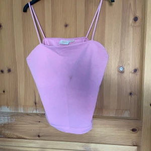 Rosa linnetopp från Gina Tricot - Säljer en söt rosa linnetopp från Gina Tricot. Toppen har smala axelband och en enkel design som passar perfekt för varma dagar. Perfekt för att styla med jeans eller kjol för en avslappnad look.