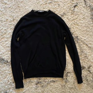 Svart merinoull tröja från ströms - Snygg svart tröja från ströms i en klassisk design. Nypriset på tröjan ligger runt 1600kr. Tröjan har långa ärmar och en rund halsringning, perfekt för en stilren look. Passar bra till både jeans och chinos. Tröjan har en liten defekt på ärmen darför lägre pris. Men syns knappast när man har på sig den. Är osäker på storleken men fråga på om du vill ha mått😁.