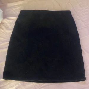 Svart kjol i XS - Snygg svart kjol i en klassisk design. Perfekt för att matcha med olika toppar och accessoarer. Enkel och stilren, passar till många tillfällen.
