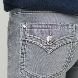 Grå bootcut jeans med brodering  - Snygga grå bootcut jeans med dekorativa sömmar på bakfickorna. Jeansen har en klassisk femficksdesign och en knappgylf. Storlek 170.Typ oanvända.💓