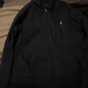 Mörkblå hoodie från Ralph Lauren - Säljer en stilren Mörkblå Ralph Lauren kofta . 400kr. Kan mötas i Södra Stockholm 