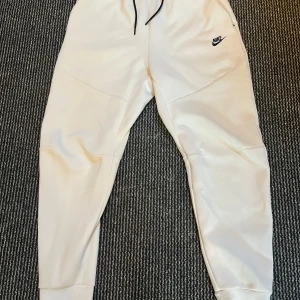 Nike tech mjukisbyxor - Vita Nike tech mjukisbyxor. Endast andvända några gånger inomhus därför finns den inga fläckar eller märken på byxorna. Dem är som nya i perfekt skick. 