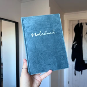 Blå anteckningsbok med sammetstextur - Säljer en elegant blå anteckningsbok med mjuk sammetstextur och texten 'Notebook' i vitt på framsidan. Boken har linjerade sidor, perfekt för anteckningar eller dagboksskrivande. En stilren och praktisk bok för alla dina skrivbehov. Oanvänd. Önskar du veta exakta mått? Tveka inte att höra av dig!
