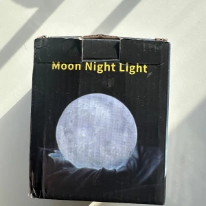 Moon Night Light - Säljer en Moon Night Light som ger ett mjukt och behagligt sken. Perfekt för att skapa en mysig atmosfär i rummet. Lampan är formad som en måne och kommer i en snygg förpackning.