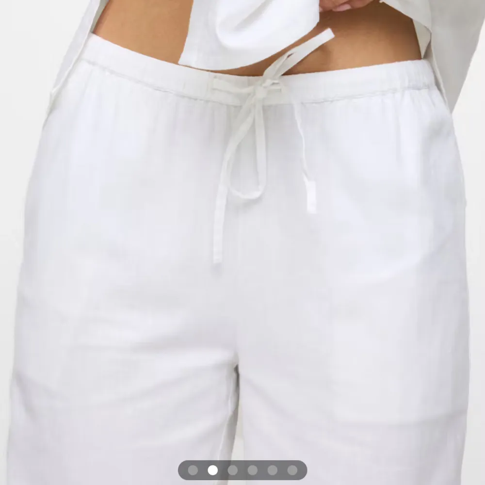Snygga och bekväma vita linnebyxor med dragsko i midjan. Byxorna har en loose passform och är perfekta för varma dagar. De är högmidjade och har en stilren design som passar till många olika tillfällen. High waist. Farkut & Housut.