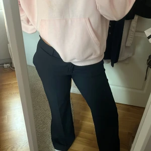 Marinblå kritstäckrandiga kostymbyxor - Snygga marinblå krotsträckrandiga kostymbyxor från Zara. Lågmidjade och utsvänga ben. Sitter skitsnyggt. Storlek L.