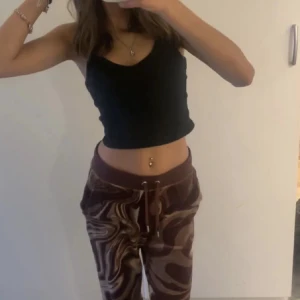 Bruna mönstrade mjukisbyxor från Juicy Couture 💕💕 - Säljer ett par bruna mjukisbyxor från Juicy Couture med ett unikt mönster. Byxorna har snörning i midjan och texten 'Juicy' broderad på baksidan. Går ej att hitta längre, orginalpris 800 därav priset 💕💕Ger en fyllig look.