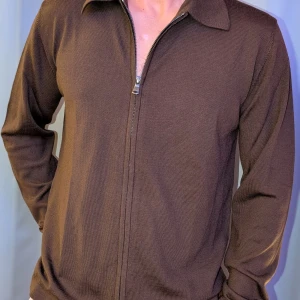 J.Lindeberg Cardigan / skjorta i färgen Chocolate. HELT NY! - J.Lindeberg "Kaleb Merino Zip Cardigan" i färgen Chocolate.  Skjorta/cardigan med tvåvägs dragkedja framtill. Tillverkad i 100 % Merino Ull från Italien.  Aldrig använd, helt ny med prislapp kvar. Nypris 1800  Storlek S, dock stor i storleken då jag vanligtvis har stl M (177cm/70kg.) och den här sitter perfekt på mig.  Skickar gärna fler bilder vid förfrågan.  Hämtas centrala Göteborg eller skickas mot frakt 