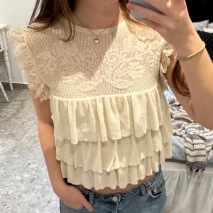 Stickad zara topp - Beige stickad zara topp med volanger. Mycket fint skick, endast använd ett fåtal gånger! Storlek M men ganska liten i storlek. Passar mig som brukar ha S-M. ”Genomskinlig” på övre delen av toppen. 