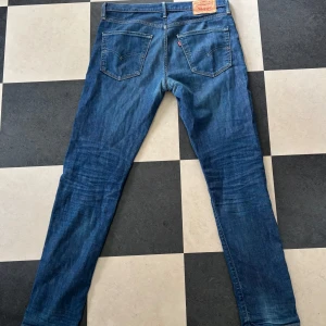 Levis 501 blå jeans - Klassiska blå Levis 501 jeans med raka ben och normal passform. Jeansen har fem fickor och Levis-lapp bak i midjan. Mycket fina!!
