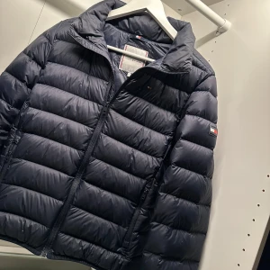  Tommy Hilfiger- ESSENTIAL LIGHT DOWN JACKET - Säljer en marinblå höst/vårjacka från Tommy Hilfiger i modellen: BLÅ U ESSENTIAL LIGHT DOWN JACKET. Jackan är i storlek 176 och är så gott som ny. Priset kan diskuteras. (Äkta) 