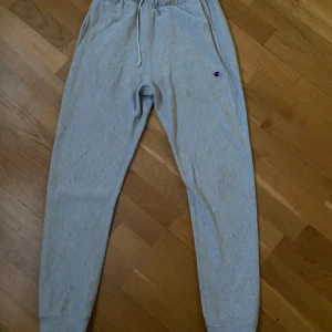 Grå mjukisbyxor från champion  - Säljer ett par ljusgrå mjukisbyxor från Champion i modellen Reverse Weave. Byxorna är i storlek XS och har resår i midjan med snörning och muddar vid bensluten. Perfekta för en avslappnad stil och har en liten Champion-logga på benet. Köp gärna i bundle 