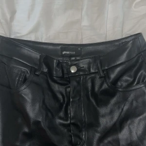 Svarta skinnbyxor från Gina Tricot - Säljer ett par svarta skinnbyxor från Gina Tricot. Passformen på byxorna är raka, storlek xs 