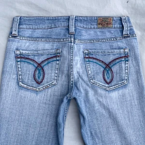 Lågmidjade bootcut jeans med snygga detaljer - Midja 37x2 cm, gren 21 cm, innerben 71 cm o benslut 23x2 cm❤️märkta amerikansk storlek 3