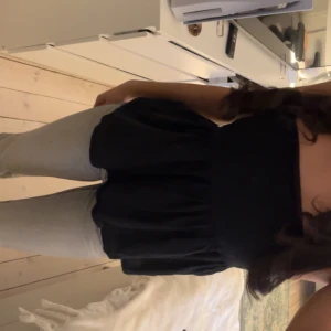 Svart volangtop med smala axelband - Sött svart linne med tunna axelband. Säljs då den inte kommer till användning🫶