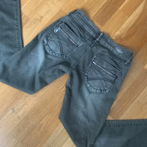 Lågmidjade jeans  - Säljer ett par gråa/khaki Lågmidjade bootcut jeans. Omsydda till bootcut, gott skick. Skriv för fler frågor! 