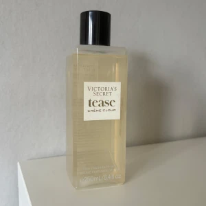 Victoria's Secret Tease Crème Cloud Body Mist - En fräsch body mist från Victoria's Secret i doften Tease Crème Cloud. Flaskan är genomskinlig med svart lock och rymmer 250 ml. Doften är söt och krämig, perfekt för dig som gillar mjuka och feminina toner. Ny pris 315 kr i Victoria Secrets hemsida