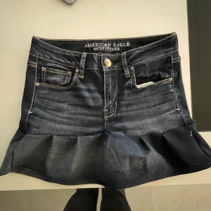 Mörkblå jeanskjol med volang från American Eagle Outfitters - Säljer en mörkblå jeanskjol från American Eagle Outfitters med volang nertill. Perfekt till sommarn🥰