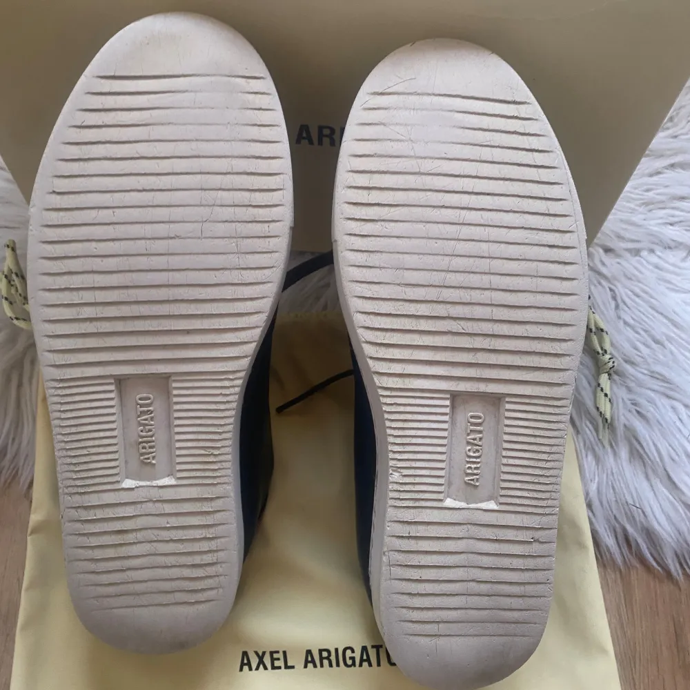 Snygga svarta sneakers från Axel Arigato med broderad blå fågel på sidan och vit sula. Skorna har snörning och är tillverkade i skinn. Levereras med originalkartong och dustbag. Skriv för mer bilder och information . Kengät.