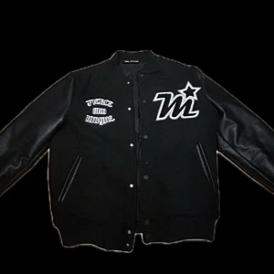 Svart varsityjacka från Zara - Säljer en svart varsityjacka från Zara med broderad text 'Fierce and Unique' på både fram- och baksidan. Jackan har långa ärmar i skinnimitation, tryckknappar och quiltat foder. Nästan helt ny har andvänts Max 2 gånger. Pris diskuteras 