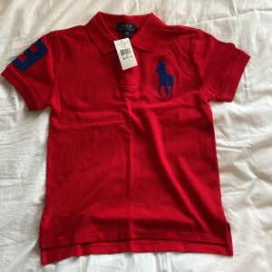 Röd pikétröja från Polo Ralph Lauren - Säljer en klassisk röd pikétröja från Polo Ralph Lauren. Köpt för ca 450 kr vårt pris bara 300 helt ny med lappen kvar, aldrig använd. Storlek 10-12 i barn så cirka xxs xxxs 