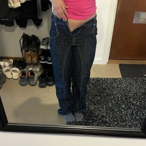 Mörkblå baggy jeans - Säljer ett par mörkblå baggy jeans med vita detaljer från only. Byxorna har låg midja och har dragsk vid ben öppningen