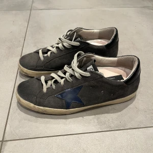 Golden goose skor - Säljer nu mina sälltsynta ggdb skor, som är i en grå mocka med blå stjärna. Skick 8,5-10 och säljer för endast 999kr. Säljer dem eftersom de blivit för små. Strl: 40. Hör av dig vid minsta fundering. 