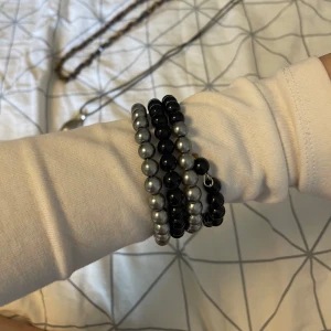 Svart och silverfärgat pärlarmband - Coolt armband med stora pärlor i svart och silver. Armbandet är elastiskt och snurrar flera varv runt handleden för en chunky och trendig look. 