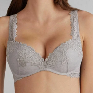 Bh från intimissimi ❤️ - Supersnygg grå bh med v-ringning och breda axelband, dekorerad med vacker spets över kuporna och längs kanterna. Perfekt för att ge en feminin touch till din outfit. Materialet känns mjukt och bekvämt mot huden. Ger super fin push❤️ Storlek 75C.