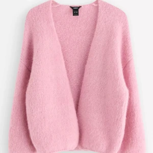 Ljusrosa stickad kofta från Lindex - Supermysig ljusrosa stickad kofta från Lindex med loose passform och långärmade ärmar. Koftan har en öppen front utan knappar och är fluffig och mjuk i materialet. Perfekt att slänga över en klänning eller t-shirt för en chill look. Priset kan diskuteras!🤗