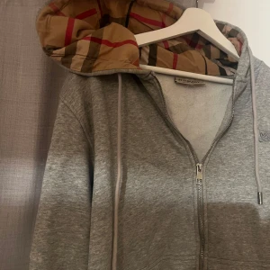 Grå Burberry hoodie med klassisk huva - Grå hoodie från Burberry med dragkedja och snörning. Priset går att diskutera 
