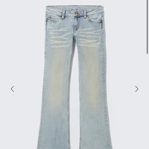 Bootcut jeans från Cheap Monday ljusblå - Säljer ett par ljusblå bootcut jeans från Cheap Monday med klassisk femficksdesign och slitna detaljer framtill. Jeansen har låg midja och är tillverkade i en mjuk bomullsblandning med polyester och elastan för extra stretch. Perfekt för dig som gillar retrovibbar och snygg passform.