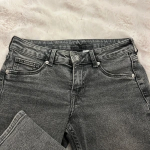 Grå jeans från Divided - Snygga grå jeans från Divided som är low waist och bootcut. Jeansen har en cool tvättad look, bälteshällor och knappgylf. Säljer pga kommer ej till användning ❣️