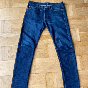 A.P.C Raw. New Cure H - Säljer ett par A.P.C. New Cure jeans i klassisk blå denim. Modellen är slim med raka ben och fem fickor. Jeansen är tillverkade i 100% bomull och har snygga kontrastsömmar. Perfekta för dig som gillar minimalistisk och clean stil.