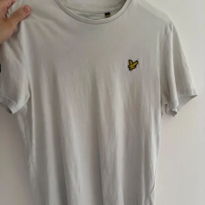 Vit t-shirt från Lyle & Scott - Snygg vit t-shirt från Lyle & Scott. T-shirten har rund hals och korta ärmar, perfekt basic-plagg. Något eller 1-2 år gammal. ✅ Nypris: 399 kr 