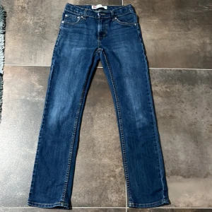 Levi's 511 Slim blå jeans - Säljer ett par blåa Levi's 511 Slim jeans i storlek 12A. Jeansen är använda ett antal gånger men har inga tecknen på användning. Passformen är slim fit och sitter ganska tajt. Jag skulle säga att de passar någon som är mellan 150-160 cm lång. Om du undrar över något är det bara att fråga.😀😃😄