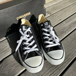 Svarta Converse Chuck Taylor sneakers - Klassiska svarta Converse Chuck Taylor All Star OX Black, sneakers med vit tå och sula, Storlek 41.5. Helt oanvänd, Orginal pris= 700 kroner, mitt pris endast 350! Pris kan diskuteras 