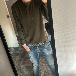 Olivgrön tröja från Jack & Jones S - Säljer en olivgrön långärmad tröja från Jack & Jones i storlek S. Tröjan har rund halsringning, ribbade muddar och är tillverkad i mjuk bomull. Enkel och clean stil som passar perfekt till jeans eller chinos.