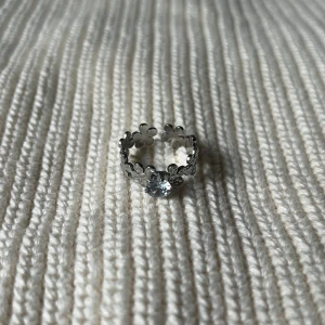 Petal Halo Ring - Ring med små blommor runt hela bandet och en klar sten framtill – romantisk och tidlös